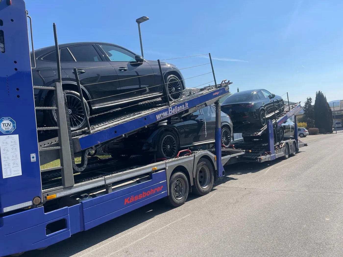 Autotransporter mit Limousine und SUV in Nahaufnahme
