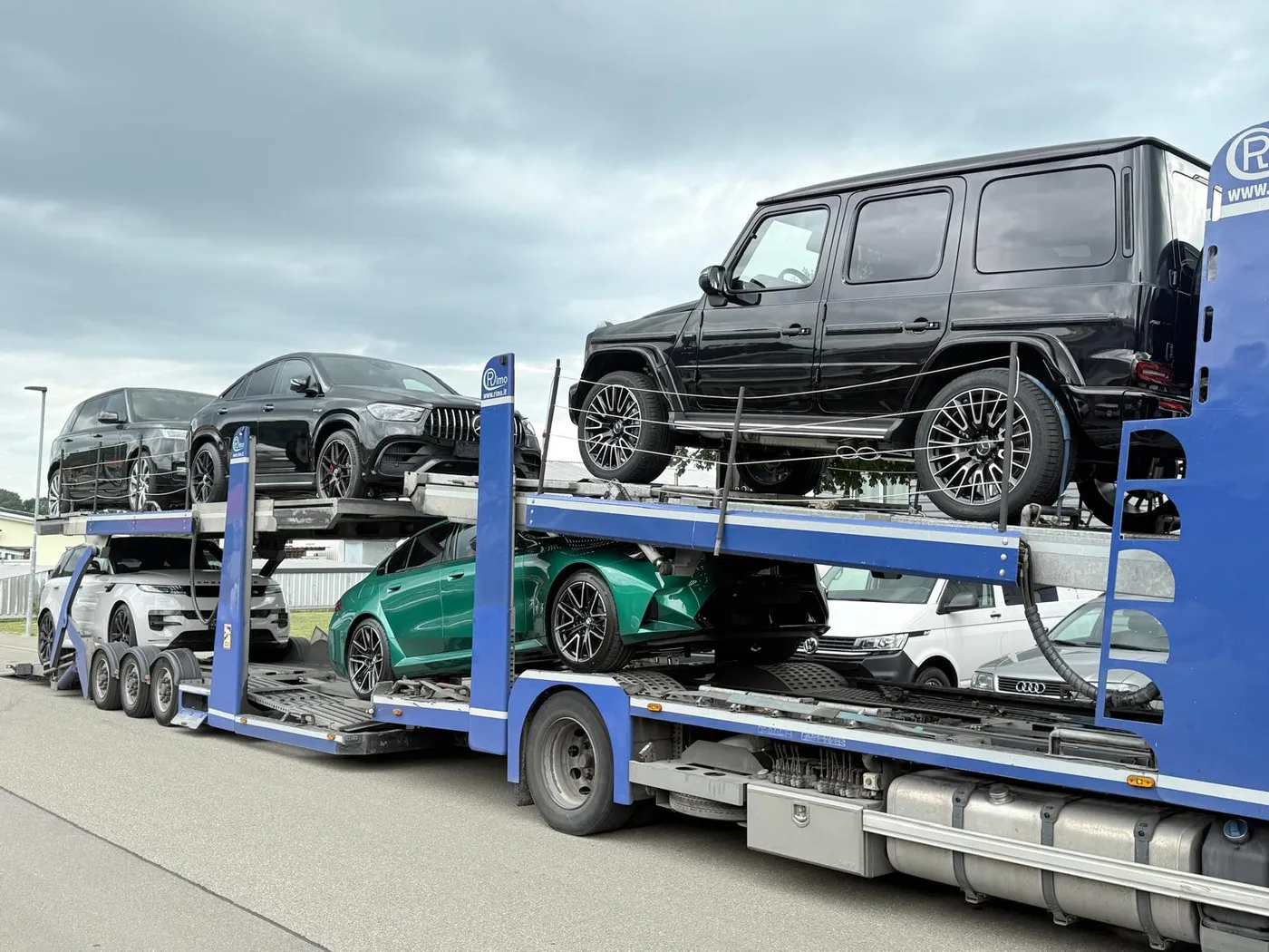 Transporter mit Geländewagen und Sportwagen